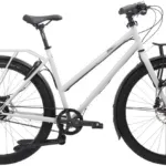 Schwarzes Tout Terrain Shopper Fahrrad mit Gepäckträgern vorne und hinten, Scheibenbremsen und Riemenantrieb auf weißem Hintergrund.