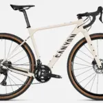Seitenansicht eines Canyon Grizl 7 Gravelbikes in heller Sandfarbe mit schwarzen Akzenten, ausgestattet mit Schwalbe G-One Reifen und DT Swiss Laufrädern.
