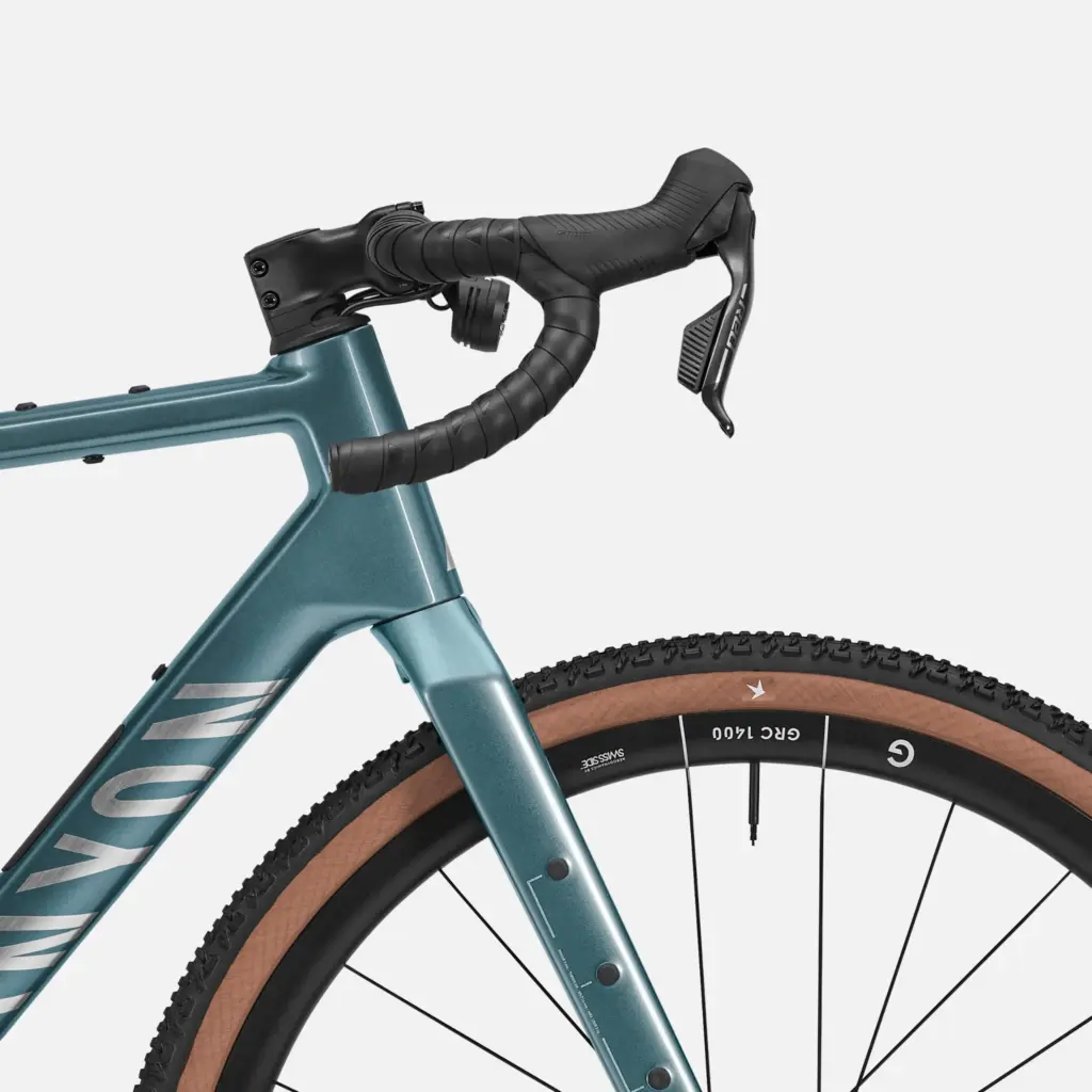 Detailansicht des blauen Canyon Grizl CF 9 Gravelbikes mit Fokus auf den Lenker und das Vorderrad