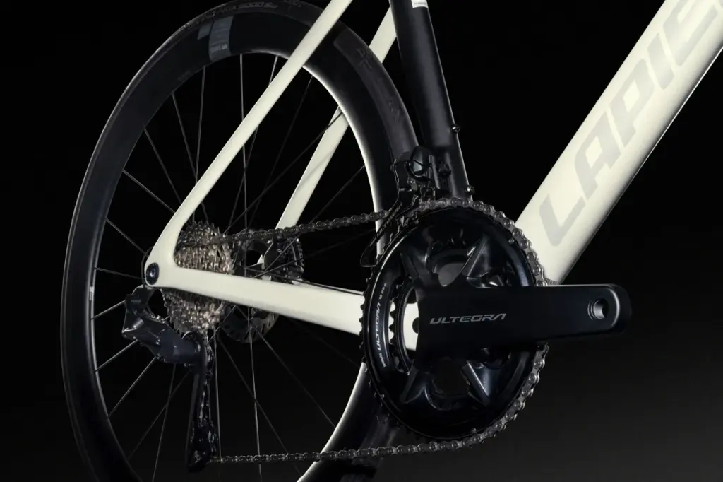 Detailansicht der Kette, des Schaltwerks und des Shimano Ultegra Kurbelsatzes eines weißen Lapierre Rennrads mit schwarzen Laufrädern.