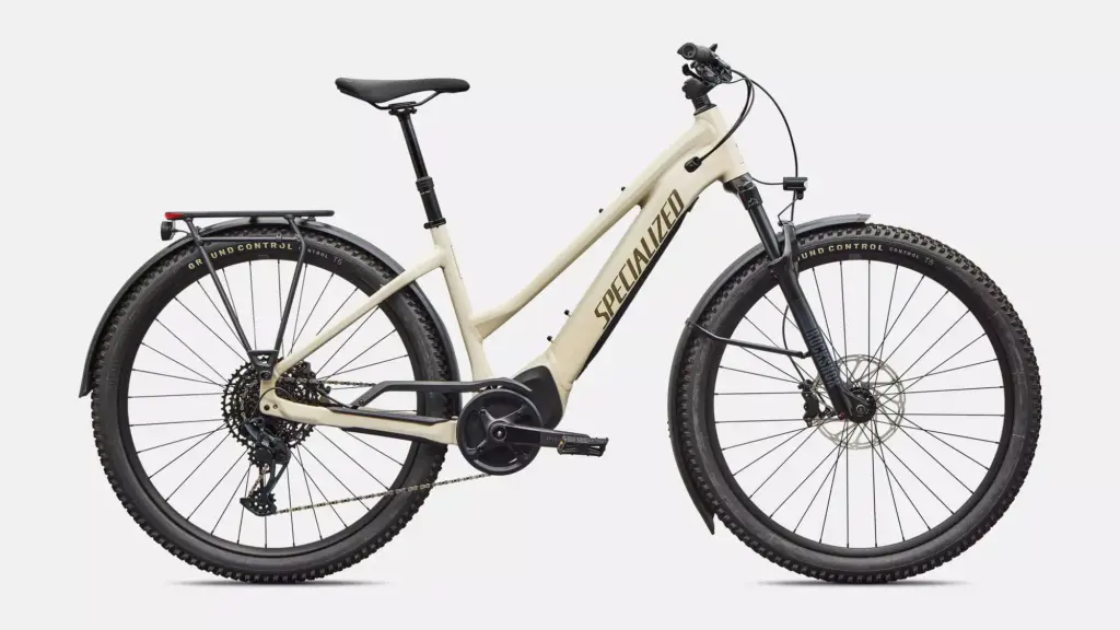 Seitliche Ansicht eines cremefarbenen Specialized Turbo Tero 5.0 EQ Step-Through E-Bikes mit Gepäckträger und Schutzblechen.