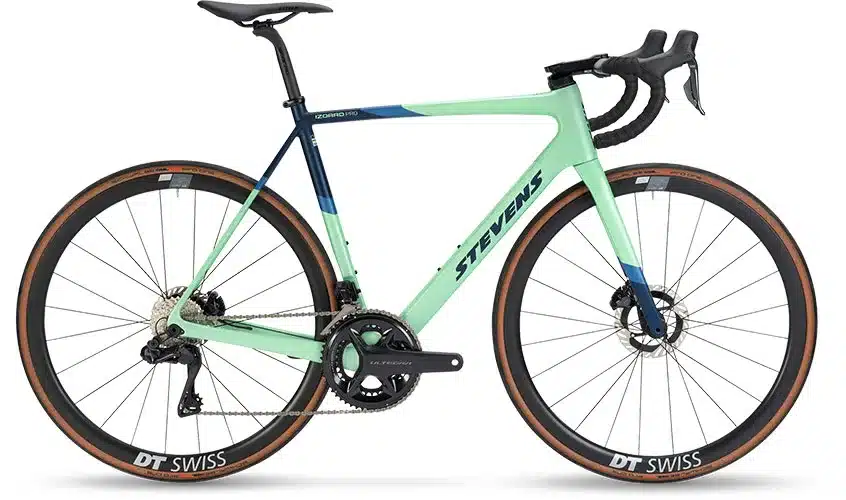 Seitenansicht eines mintgrünen Stevens Izoard Pro Disc Rennrads mit dunkelblauen Akzenten, DT Swiss Felgen und Ultegra Schaltgruppe.