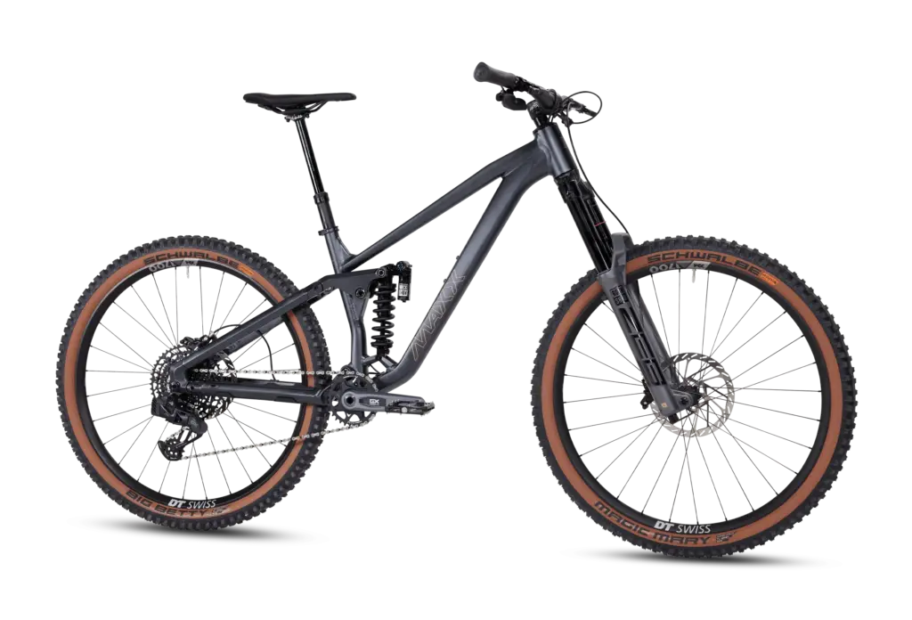 Seitenansicht eines dunklen MAXX Fab4 29 Zoll Enduro Mountainbikes mit braunen Reifenflanken und gold-orangenem MAXX-Schriftzug am Rahmen.