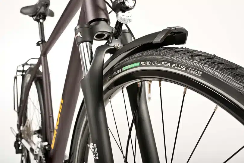 Nahaufnahme des Vorderrads eines Winora Domingo X20 Trekkingrads mit Schwalbe Road Cruiser Plus Reifen, Suntour Federgabel und Schutzblech.