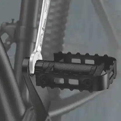 Nahaufnahme eines Fahrradpedals, an dem ein Schraubenschlüssel zur Montage angesetzt wird.