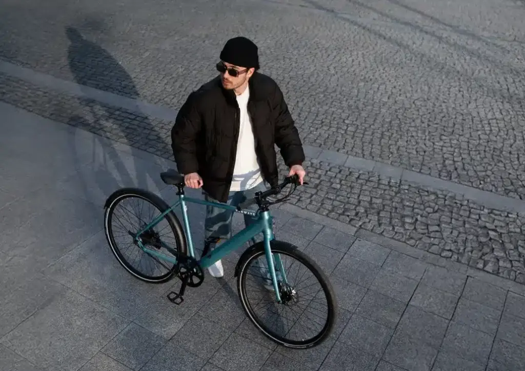 Ein Mann mit einem TENWAYS CGO600 Pro E-Bike in der Farbe Willow Mist.
