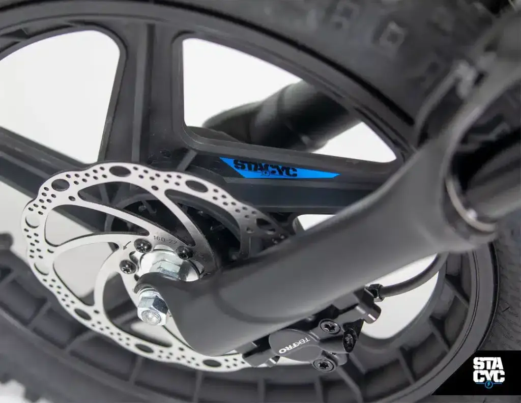 Detailansicht des Vorderrads eines STACYC 16eDRIVE ELITE 36V Elektro-Balancebikes, Fokus auf die hydraulische Scheibenbremse und das Laufrad.