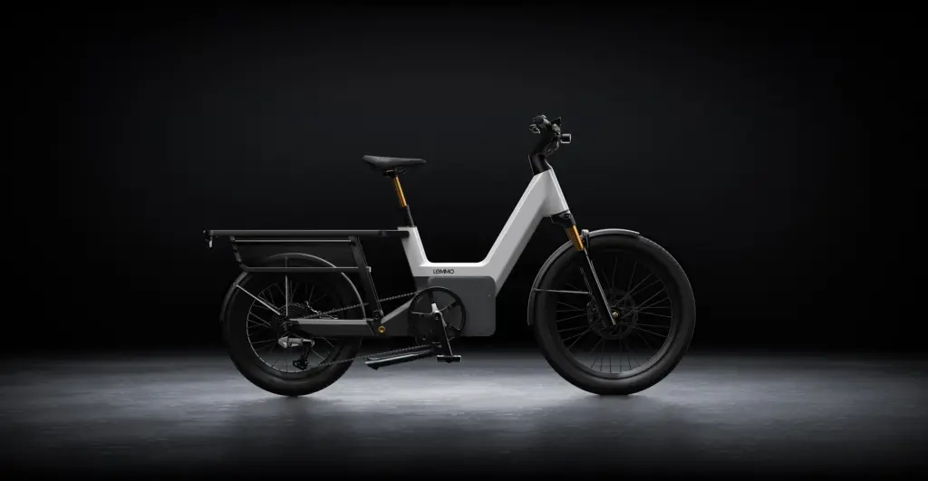 Seitenansicht eines weißen und grauen Lemmo 3 E-Bikes mit Gepäckträger hinten und niedrigem Schwerpunkt.