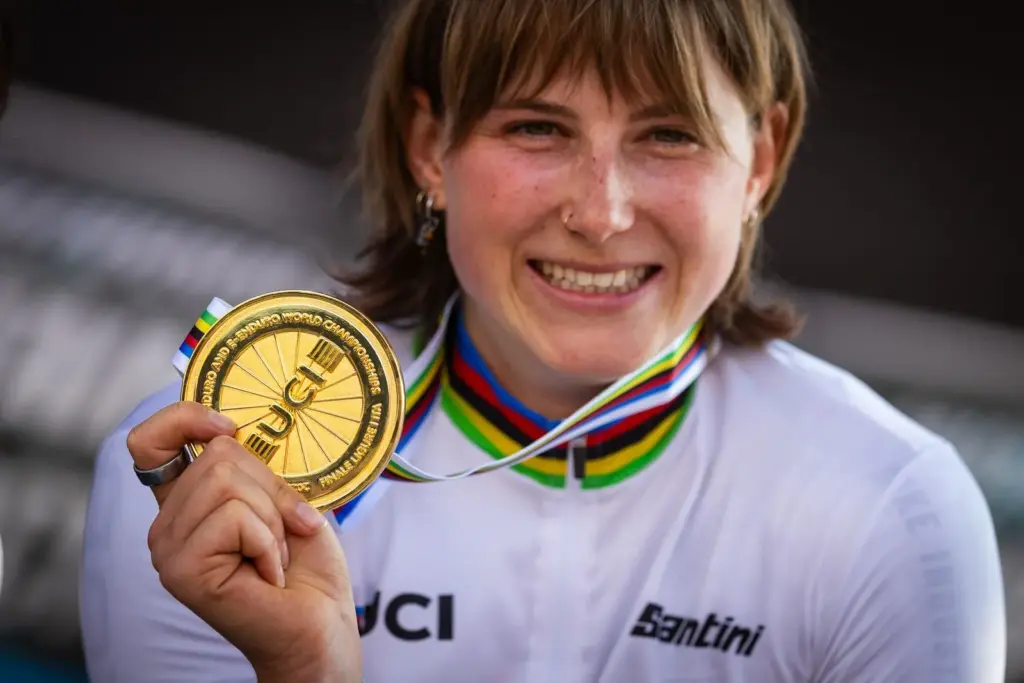 Porträt von Helen Weber, die lächelnd eine goldene UCI E-Enduro-Weltmeisterschaft Medaille hält.