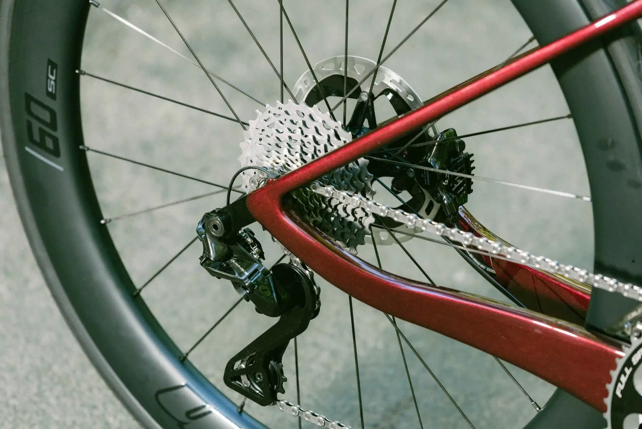 Detailaufnahme des Hinterrads mit Schaltwerk, Kassette und Bremsscheibe eines roten BH iAEROLIGHT E-Rennrads
