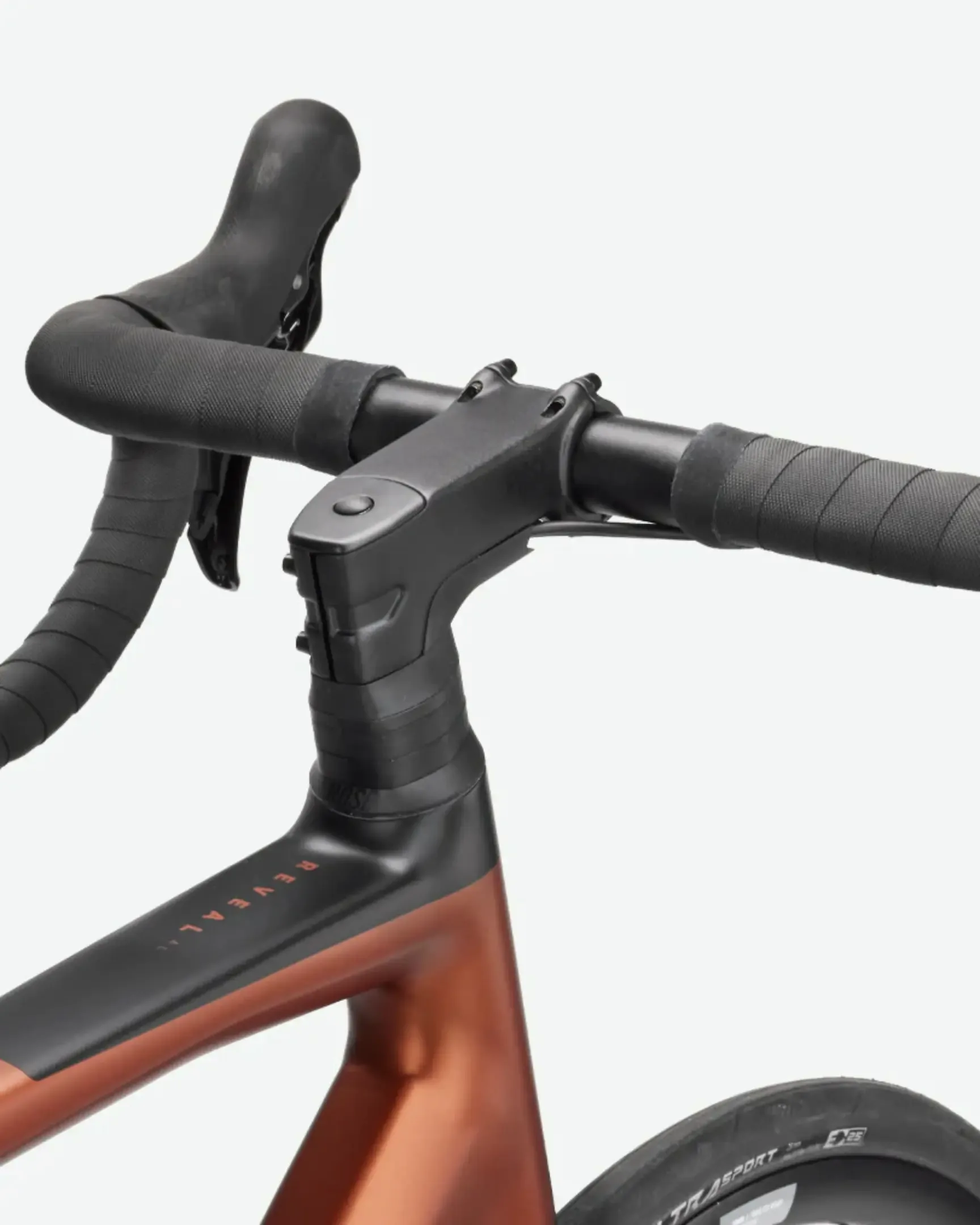 Nahaufnahme des Cockpits eines ROSE Reveal AL 105 Rennrads mit mattschwarzem Lenker und Salted Caramel Rahmen