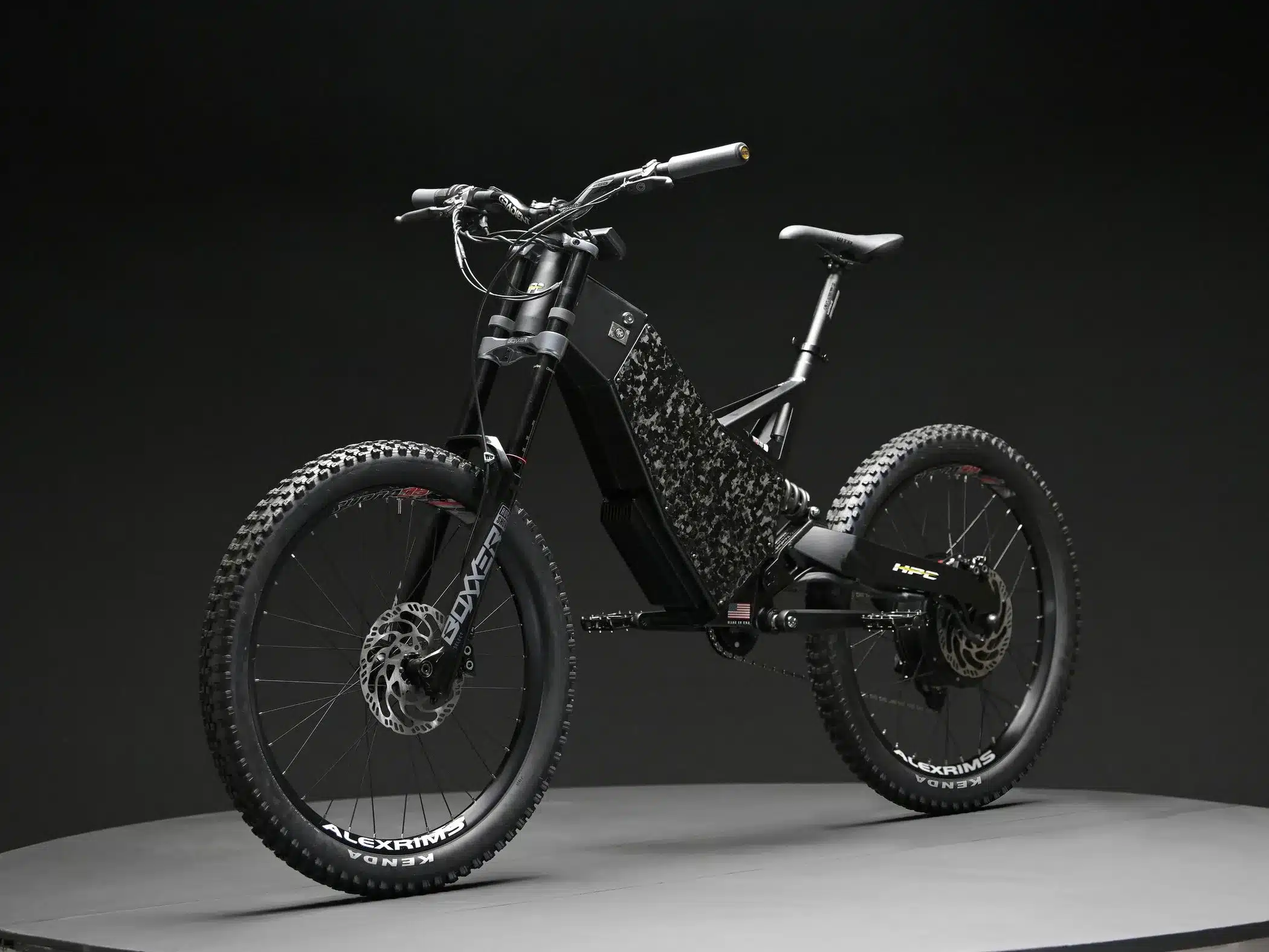 Seitenansicht des schwarzen Hi-Power Cycles 2024 Revolution Elektrofahrrads mit matt-schwarzem Rahmen und einem auffälligen Muster auf dem Hauptrohr, präsentiert vor einem dunklen Hintergrund.