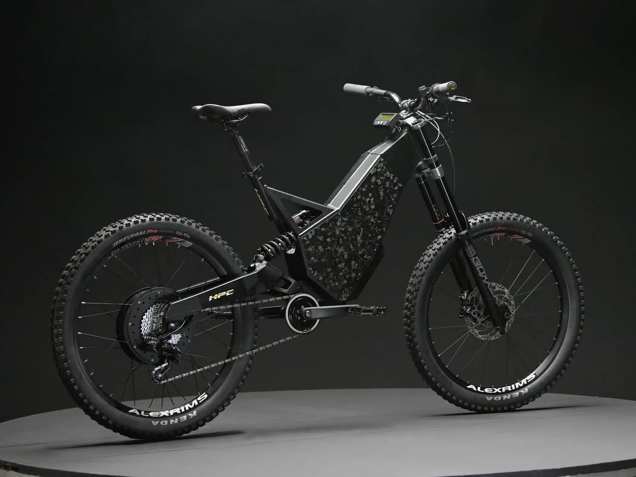 Seitenansicht eines schwarzen Hi-Power Cycles 2024 Revolution Downhill-E-Bikes mit breiten Reifen und voller Federung, stehend auf einem dunklen Podest vor schwarzem Hintergrund.