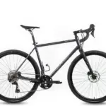 Das Böttcher Evolution Gravel CrMo Fahrrad in Dunkelblau, von vorne links betrachtet, mit Fokus auf den Rahmen, die Räder und die Schaltung.