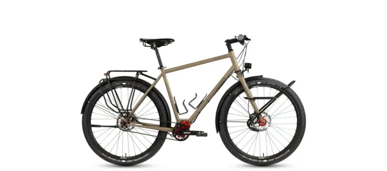 Seitenansicht eines sandfarbenen Böttcher Evolution Pinion Diamant Reiserads mit Gepäckträgern, Schutzblechen und Pinion-Getriebeantrieb.