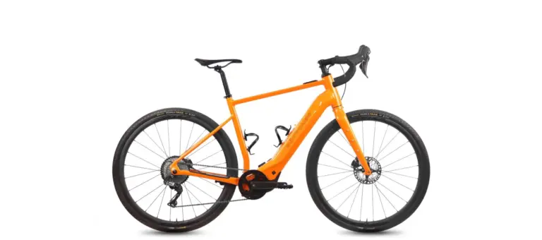 Orangefarbenes Böttcher Gravel-E SX E-Gravelbike mit schwarzen Reifen und Anbauteilen, freigestellt vor weißem Hintergrund.