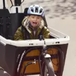 Kind mit Helm sitzt in der Transportbox eines Bergamont E-Cargoville LJ Elite Lastenrads