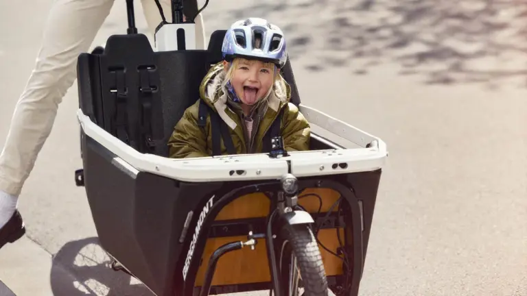 Kind mit Helm sitzt in der Transportbox eines Bergamont E-Cargoville LJ Elite Lastenrads