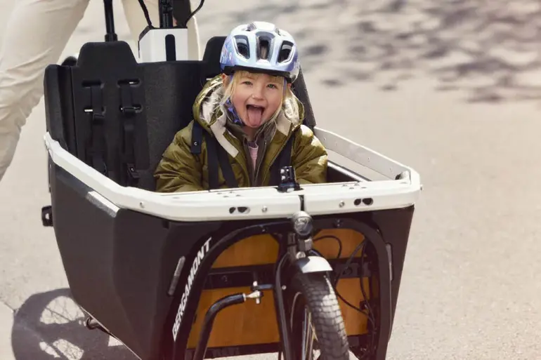 Kind mit Helm sitzt in der Transportbox eines Bergamont E-Cargoville LJ Elite Lastenrads