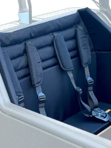 Gepolsterter schwarzer Kindersitz mit drei Gurten und Schnallen, montiert im vorderen Bereich eines grauen HNF CD2 Lastenrads.