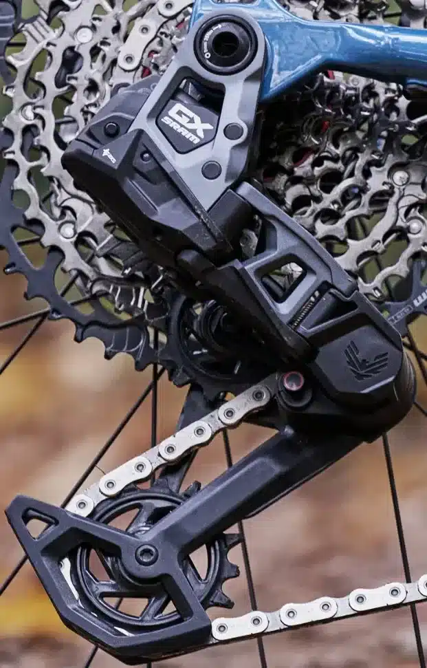 Nahaufnahme des schwarzen SRAM GX Eagle Transmission Schaltwerks mit silberner Kette und Kassette an einem Fahrrad.