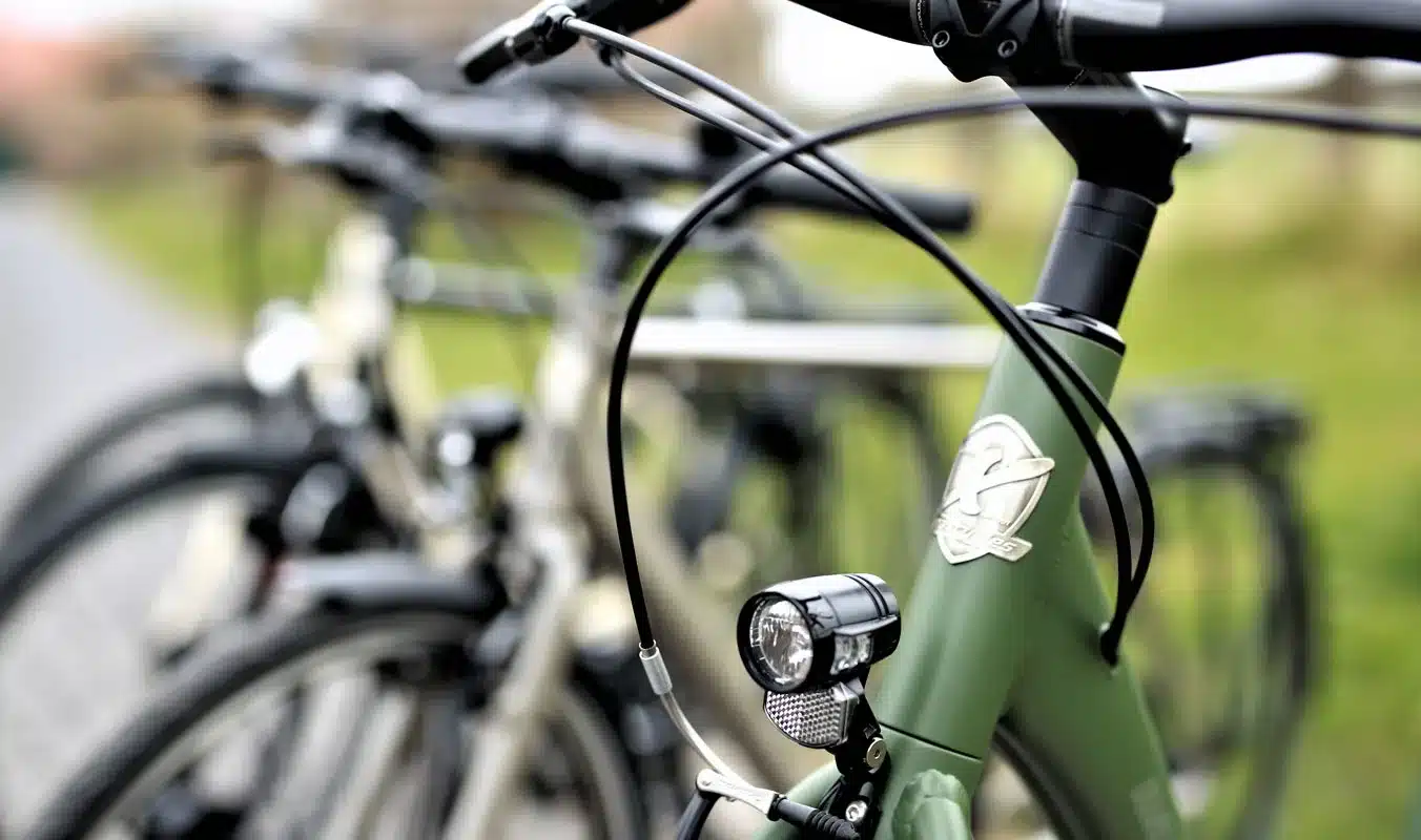 Nahaufnahme des vorderen Teils eines grünen Citybikes, Modell City Lite 2, mit Fokus auf den Lenkerbereich, den Frontscheinwerfer und das Markenlogo.