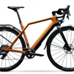 Detailaufnahme eines orangefarbenen Cyklaer Base E-Gravelbikes mit Carbonrahmen, Schutzblechen und Gepäckträger, freigestellt vor weißem Hintergrund.