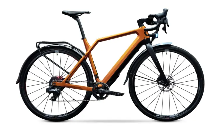 Detailaufnahme eines orangefarbenen Cyklaer Base E-Gravelbikes mit Carbonrahmen, Schutzblechen und Gepäckträger, freigestellt vor weißem Hintergrund.