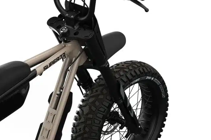 Detailaufnahme des Super73-Z Adventure Series E-Bikes, die den breiten, grobstolligen Vorderreifen und den sandfarbenen Rahmen mit dem Super73-Logo zeigt.