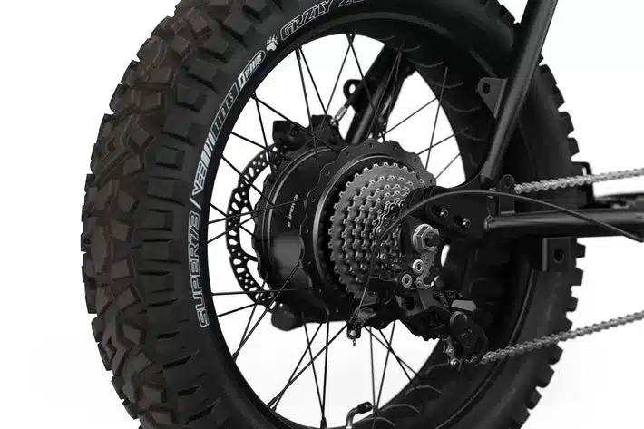 Detailaufnahme des Hinterrads eines Super73 Elektrofahrrads mit aggressiv profilierten Vee Tire Co. GRZLY Reifen, Shimano 8-Gang Kassette und Nabendynamo.