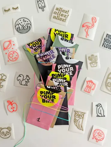 Adventskalender für Radfahrer mit bunten, einzeln verpackten Stickern aus Vinylfolie, umgeben von verschiedenen Motivstickern