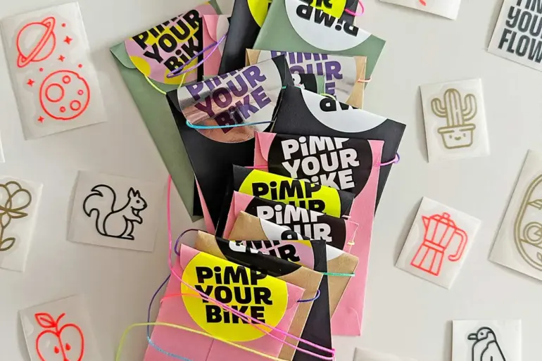 Adventskalender für Radfahrer mit bunten, einzeln verpackten Stickern aus Vinylfolie, umgeben von verschiedenen Motivstickern