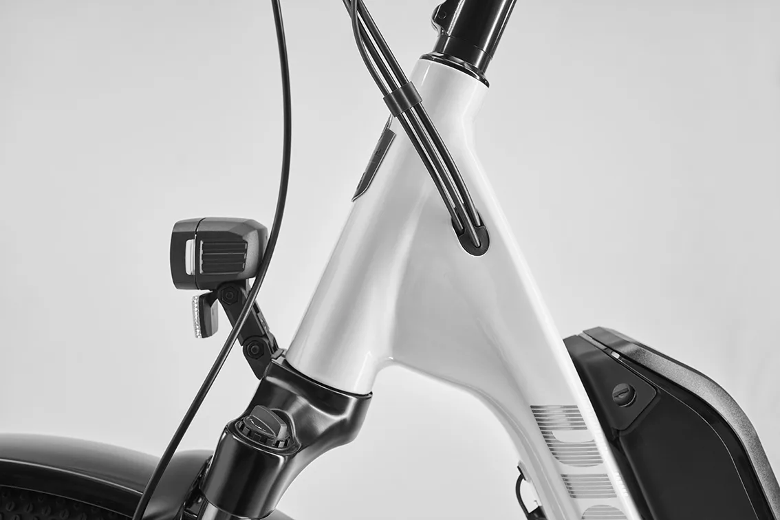 Nahaufnahme des oberen Rahmendreiecks eines E-Bikes mit Frontlicht, Kabelintegration und montiertem Akku