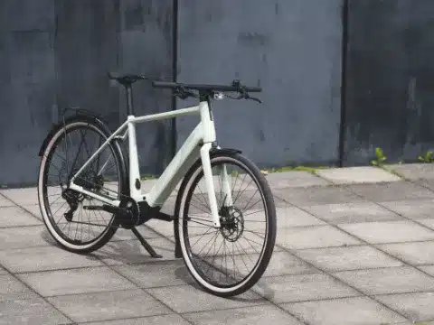 Das FLYER G1 Upstreet SL 3.63 Trapez E-Bike steht auf einem gepflasterten Platz vor einer grauen Wand