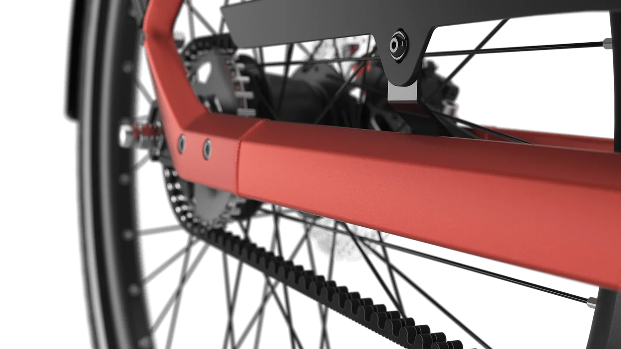Nahaufnahme des Gates-Riemenantriebs am Hinterrad eines Gazelle Ultimate C5+ E-Bikes mit orangem Rahmen