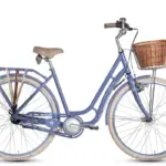 Nahaufnahme eines blauen Grecos Clara Touren Fahrrads mit beige-braunem Sattel und Lenkergriffen, einem Rattan-Korb vorne und einem Gepäckträger hinten, auf weißem Hintergrund.