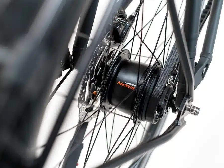 Nahaufnahme des Hinterrads eines Fahrrads, das die Shimano Nexus Nabenschaltung und den Gates Carbon Drive Riemenantrieb zeigt.