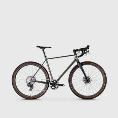 GX-1600 Gravelbike mit grünem Stahlrahmen, Carbon-Gabel und hochwertigen Komponenten, Seitenansicht vor hellem Hintergrund.