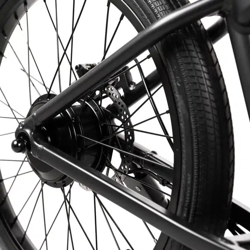 Nahaufnahme des schwarzen Hinterrads eines JackRabbit OG2 E-Bikes, wobei der Nabenmotor, die Speichen und die Scheibenbremse sichtbar sind.