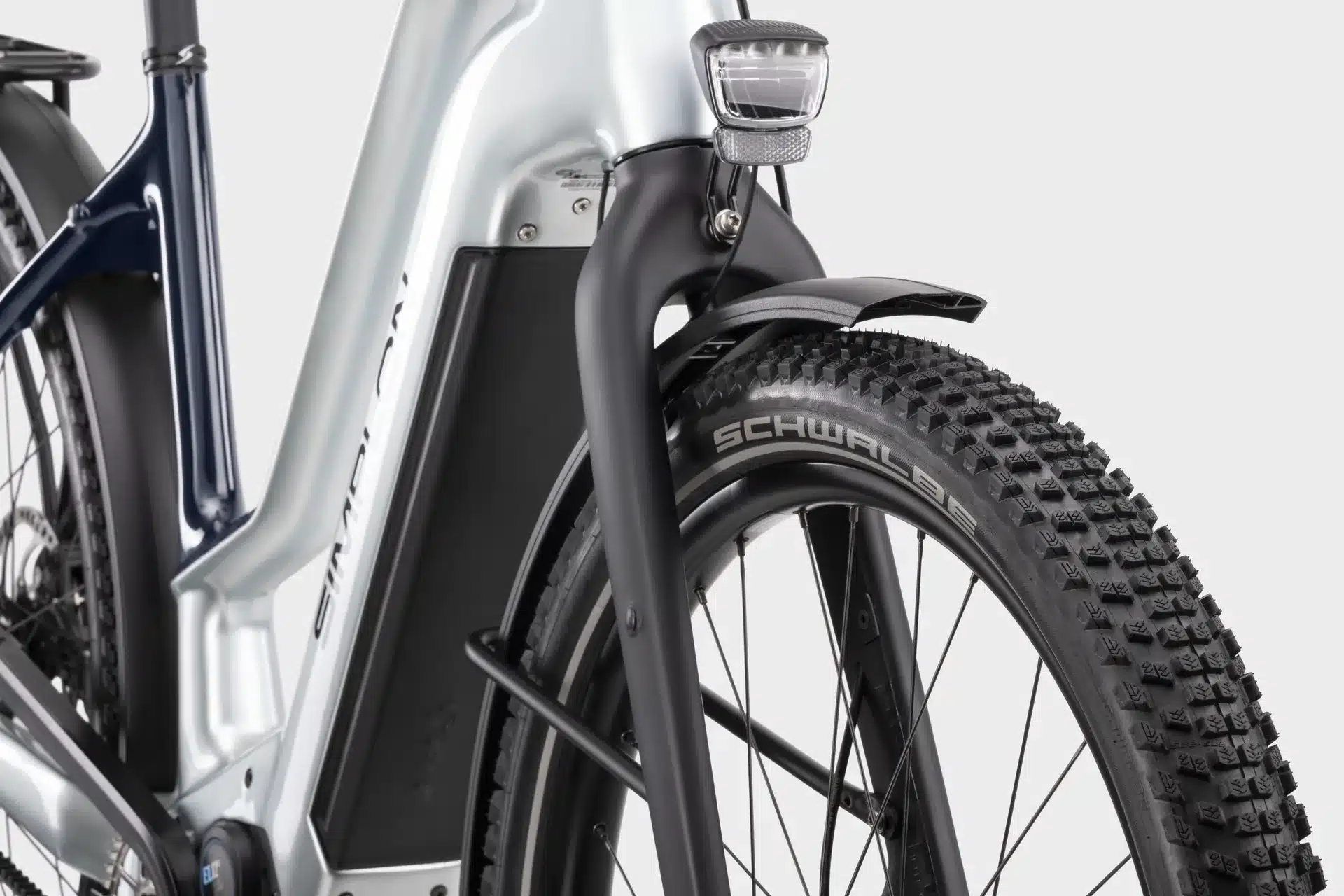 Vorderansicht eines KAGU :ePinion Mid Trekking-E-Bikes mit breitem Schwalbe Ballonreifen, schwarzem Schutzblech und integriertem Scheinwerfer.