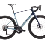 Profilansicht eines dunkelblauen und hellblauen Simplon Kiaro Endurance Rennrads mit Felgenbremsen und Schwalbe Pro One Reifen.