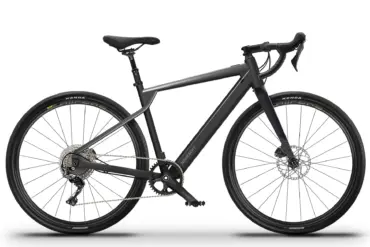 Ein schwarzes LUMO Ripio E-Gravel-Bike, von der Seite frontal fotografiert, auf einem weißen Hintergrund. Das Fahrrad hat einen Aluminiumrahmen, eine Carbon-Gabel und breite Gravel-Reifen.