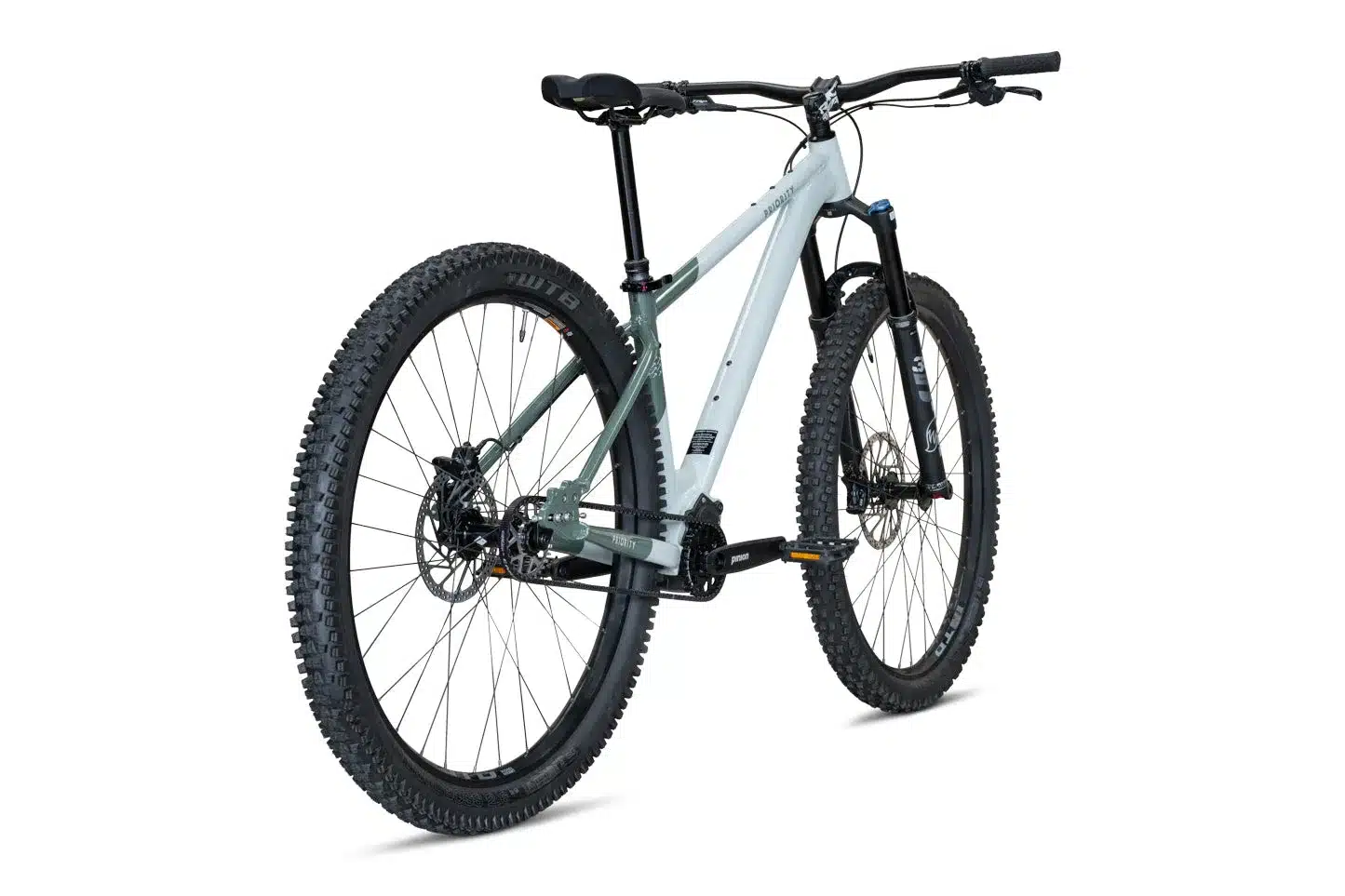 Seitenansicht eines hellgrau-grünen Priority 600HXT Hardtail Mountainbikes mit breiten Reifen, Fox Federgabel und Pinion Getriebe.