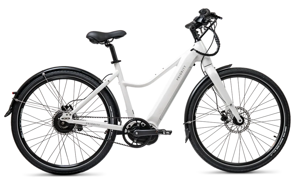 Seitenansicht eines weißen Priority Current Plus E-Bikes mit tiefem Einstieg, Riemenantrieb und Schutzblechen.