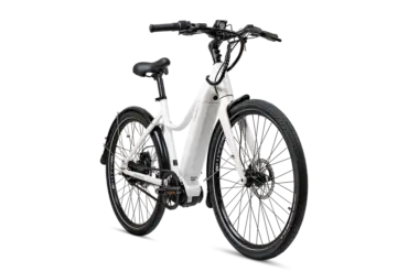 Ein weißes Current Plus E-Bike mit schwarzem Lenker, schwarzem Sattel und schwarzen Reifen, isoliert auf schwarzem Hintergrund.