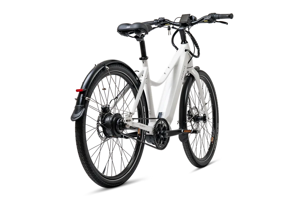 Eine Seitenansicht eines weißen E-Bikes mit Riemenantrieb, Schutzblechen und einem integrierten Akku im Rahmen.