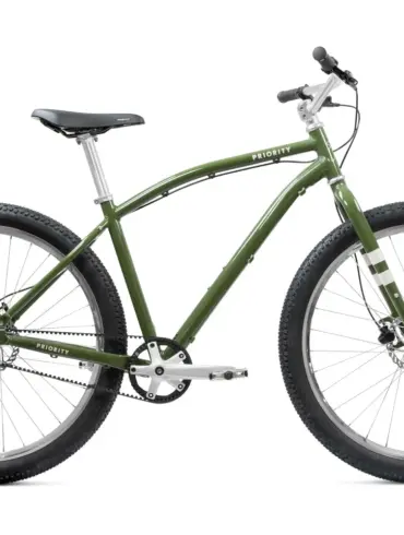 Grünes Priority Sauce Offroad-Cruiser Fahrrad, frontal leicht von links im Studio aufgenommen, mit breiten Reifen und Riemenantrieb.