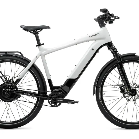 Ein weißes Priority Skyline Smart.Shift E-Bike mit Pinion Getriebe und Gates Zahnriemenantrieb, ausgestattet mit Gepäckträger und Schutzblechen.
