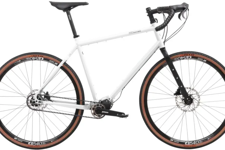 Silbernes Scrambler Xplore GT II 28 Gravelbike mit Pinion-Getriebe und Carbongabel, isoliert auf weißem Hintergrund.