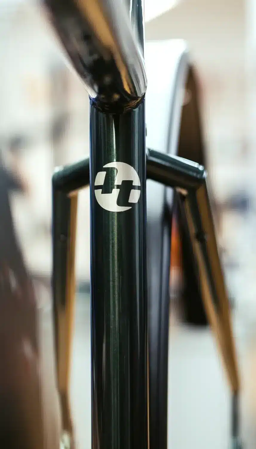 Nahaufnahme des dunkelgrünen Fahrradrahmens des Scrambler Xplore GT II 28 mit weißem Herstellerlogo (TT)